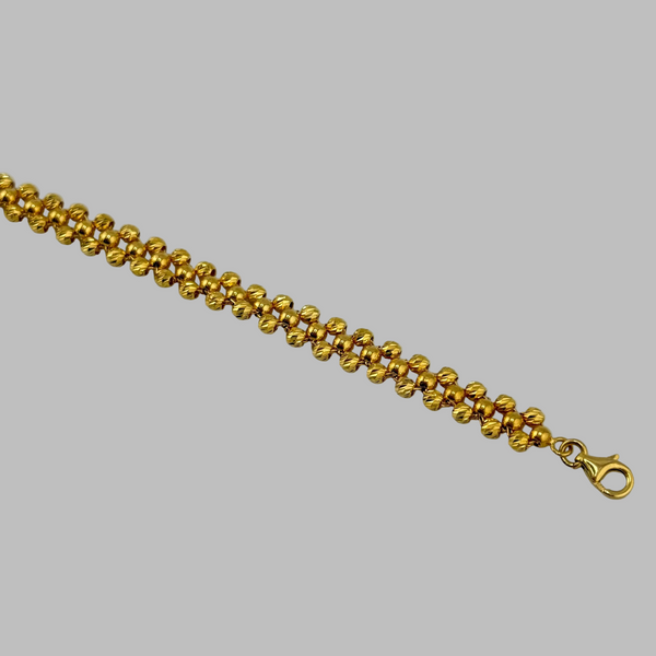 Gold bracelet on a gray background
